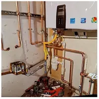 Electric water heater set on a drain pan during installation in a Harrisburg PA basement